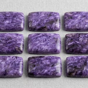 May include: Nine rectangular cabochons of polished charoite stone arranged in a three-by-three grid. Each piece features a distinct swirling pattern of deep purple, violet, and black mineral inclusions with a smooth, glossy surface finish.