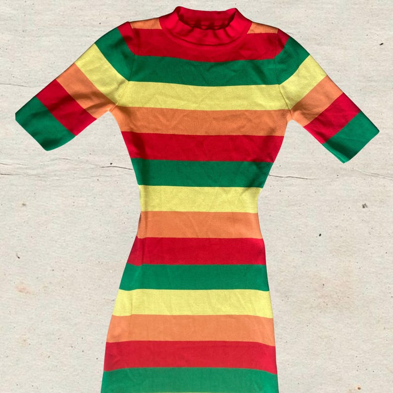 Puede incluir: Un vestido a rayas colorido con cuello alto y mangas cortas. El vestido presenta bandas horizontales rojas, verdes, amarillas, naranjas y rojas. El vestido es ajustado y parece estar hecho de tejido de punto.