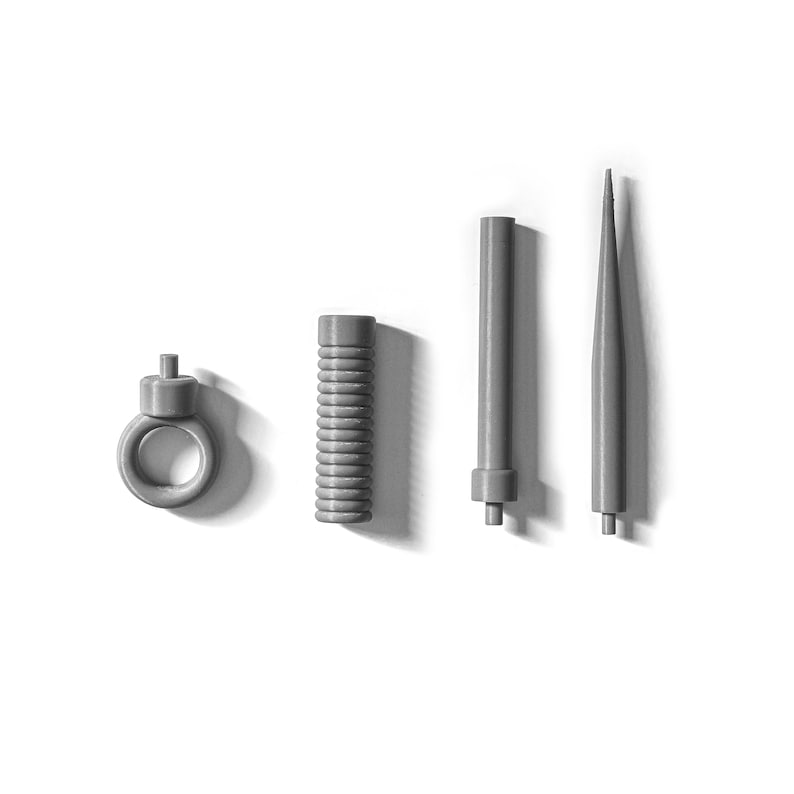 Peut inclure: Quatre outils en m&eacute;tal gris, dont un anneau, une bobine, une longue tige et une tige pointue.