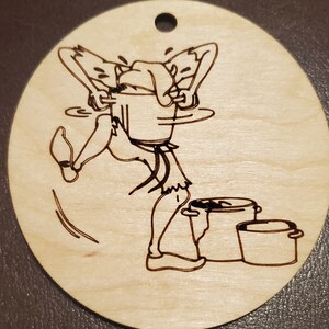 Puede incluir: Un diseño de madera quemada de un personaje de dibujos animados sosteniendo una olla sobre su cabeza, con tres ollas en el suelo debajo.