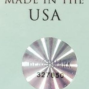 Puede incluir: Una pegatina plateada con la palabra "remarkable" y el n&uacute;mero "327850" impreso en ella. La pegatina es circular y tiene un patr&oacute;n radial.