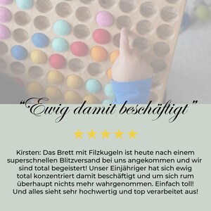 May include: A wooden board with colourful felt balls in a grid pattern. A child's hand points to one of the balls. The text "Ewig damit besch&auml;ftigt" is written in cursive above the board. Five gold stars are below the text. The text "Kirsten: Das Brett mit Filzkugeln ist heute nach einem superschnellen Blitzversand bei uns angekommen und wir sind total begeistert! Unser Einj&auml;hriger hat sich ewig total konzentriert damit besch&auml;ftigt und um sich rum &uuml;berhaupt nichts mehr wahrgenommen. Einfach toll! Und alles sieht sehr hochwertig und top verarbeitet aus!" is below the stars.