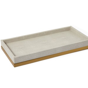 Może przedstawiać: Prostokątna taca z jasnobeżową podszewką z tkaniny i złotą obwódką. Taca idealnie nadaje się do organizowania drobnych przedmiotów.