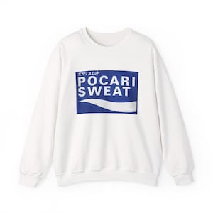 May include: White crew neck sweatshirt with the text "POCARI SWEAT" in a blue rectangle. The sweatshirt has long sleeves and a simple design, suitable for casual wear. The text is in both English and Japanese.