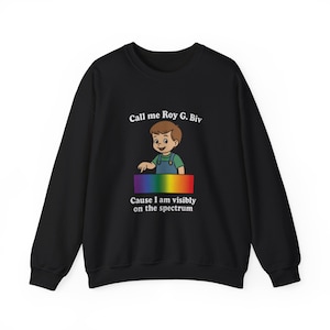 May include: Black crewneck sweatshirt with a cartoon illustration of a boy and a rainbow spectrum. The text reads "Call me Roy G. Biv" and "Cause I am visibly on the spectrum."