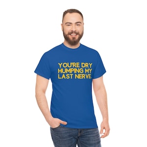 Puede incluir: Una camiseta azul real con el texto "YOU'RE DRY HUMPING MY LAST NERVE" en amarillo.