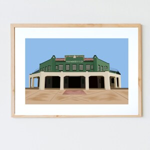 May include: A framed art print featuring a stylized illustration of Rickwood Field, a historic baseball stadium. The artwork depicts the stadium's green facade, white columns, and the text "RICKWOOD FIELD" against a blue sky background. The print is in a light wood frame.