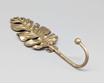 Gancho de pared de metal con hoja dorada