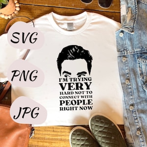 May include: White t-shirt with a black and white illustration of a man's face and the text "I'm trying very hard not to connect with people right now."