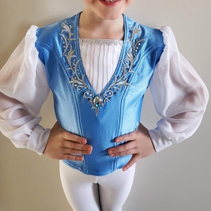 May include: A blue and white dance costume with a white bodice and long sleeves. The bodice has a decorative design with silver and blue embellishments. The sleeves are white and puffy.