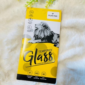 May include: A yellow and white package for a tempered glass screen protector for an iPhone 13 Pro Max. The package features a lion graphic and the text "Tempered Glass Expertise New Experience".
