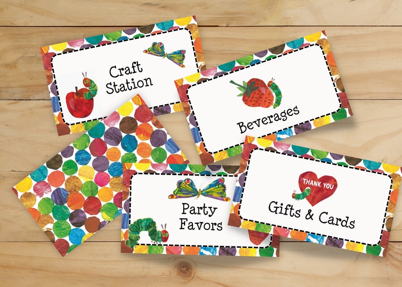 May include: Five colourful table cards with a The Very Hungry Caterpillar theme. The cards feature a caterpillar, an apple, a butterfly, a strawberry, and a heart. The text on the cards reads: Craft Station, Beverages, Party Favors, Gifts & Cards, and Thank You.