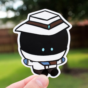 May include: A white sticker with a cartoon character wearing a white hat with a brown band and a blue gem. The character has a black face with two blue eyes.