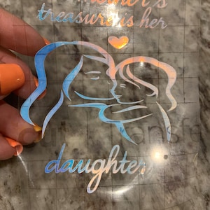 May include: A mother and daughter are depicted in a silhouette with a heart above them. The text reads "A mother's treasure is her daughter".