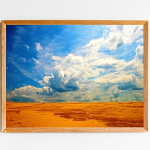 May include: A framed photograph of a bright blue sky with fluffy white clouds over a golden field.