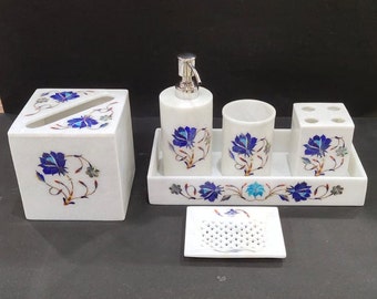 May include: White marble bathroom set with blue floral inlay. The set includes a soap dispenser, toothbrush holder, tumbler, soap dish, and tissue box.