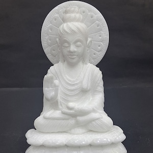 Op de afbeelding: Wit marmeren beeld van een zittende Boeddha met een halo en een lotusbasis.