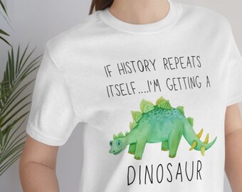 May include: White t-shirt with a green dinosaur illustration and the text "If history repeats itself... I'm getting a dinosaur."