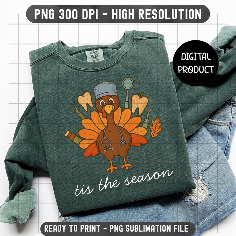 May include: A dark green sweatshirt with a turkey graphic wearing a dentist's hat and stethoscope, surrounded by teeth and dental tools. The text "tis the season" is written in white script. The sweatshirt is paired with blue jeans.