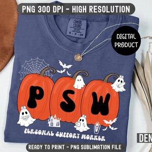 以下が含まれることがあります： ネイビーブルーのTシャツ。オレンジ色のカボチャが3つ並び、文字「PSW」を形成。デザインには、お化け、コウモリ、クモの巣が含まれ、「PERSONAL SUPPORT WORKER」の文字が書かれています。デジタル製品で、印刷可能です。