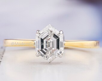 May include: A gold band engagement ring with a hexagonal cut diamond.