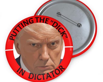 May include: A red button with the text "PUTTING THE "DICK" IN DICTATOR" encircling a portrait. The button has a silver pin back.