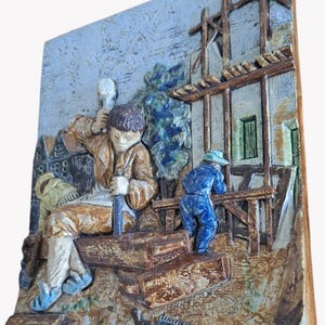 Puede incluir: Escultura en relieve de cerámica que representa una escena de construcción. Una figura con chaqueta marrón y zapatos azules talla madera con martillo y cincel. Otra figura con mono azul trabaja en una estructura de madera. Una sierra abajo.