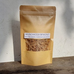Puede incluir: Una bolsa de papel marrón con una etiqueta blanca que dice "MUSCHIO DI SFAGNO per tane umide e substrato per piante". La bolsa contiene musgo sphagnum seco.