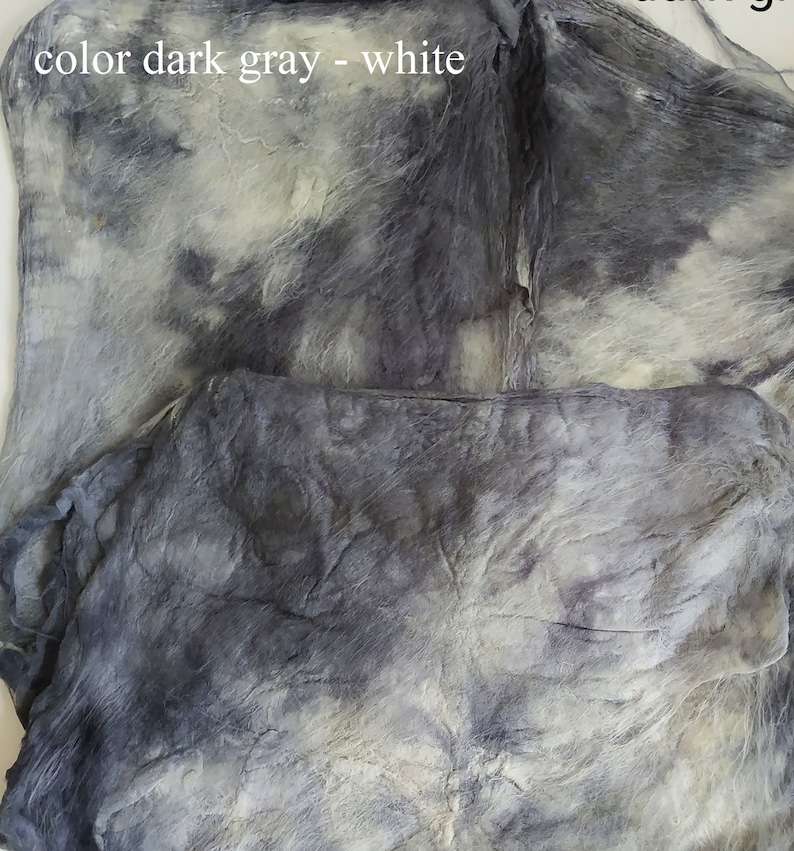 May include: Close-up of a dark gray and white fabric with a tie-dye pattern. The fabric is soft and textured, with a subtle sheen.