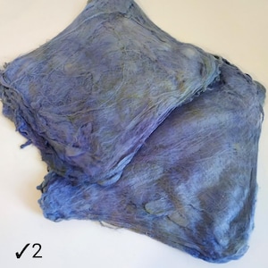 May include: Two pieces of blue and purple fabric with a textured, woven look. The fabric is folded and stacked on top of each other.