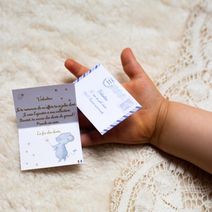 Op de afbeelding: Een kleine blauwe envelop met een witte rand en een blauw-witte postzegel. De envelop is geadresseerd aan Valentine en zegt "Aan de tandenfee".  Een kleine kaart met een blauwe muis die een ster vasthoudt en de tekst "La fee des dents" ligt naast de envelop.