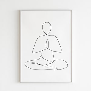 Puede incluir: Una impresi&oacute;n art&iacute;stica minimalista enmarcada que presenta un dibujo de l&iacute;nea negra continua de una persona en una postura de yoga sentada con las manos en oraci&oacute;n. La obra de arte est&aacute; sobre un fondo blanco.