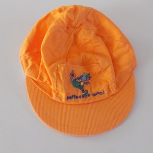 Peut inclure: Casquette en velours côtelé orange vif avec une visière incurvée. La casquette présente un personnage de dessin animé brodé et le texte "petites souris verte!" sur le devant. Casquette pour enfants.