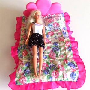 Vintage 1990 bed for Barbie with pink bedspread.