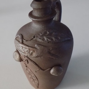 Bouteille carafe pichet Calvados avec anse en terre cuite marron , vintage année 1970.