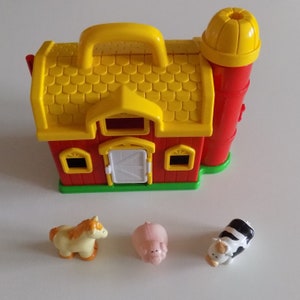 Puede incluir: Un granero de juguete de plástico rojo con un techo amarillo y un silo. El granero tiene una puerta y ventanas. Hay tres animales de granja de plástico: un caballo, un cerdo y una vaca.
