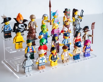 May include: A collection of colorful Lego minifigures displayed on a clear, tiered stand. The figures represent various characters, including a knight, a pharaoh, a superhero, and an alien. Each figure is approximately 2 inches tall.