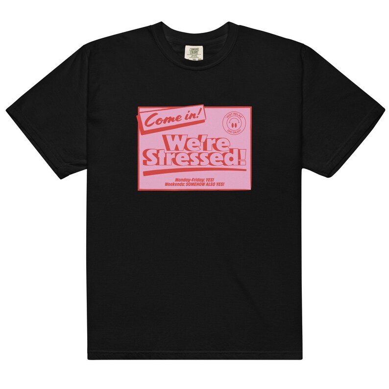 K&ouml;nnte beinhalten: Schwarzes T-Shirt mit einer pinkfarbenen Grafik, auf der "Come in! We're Stressed!" steht, darunter der Text "Monday-Friday: YES! Weekends: SOMEHOW ALSO YES!"