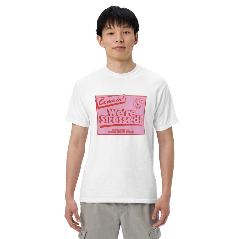 K&ouml;nnte beinhalten: Wei&szlig;es T-Shirt mit einer pinkfarbenen und roten Grafik, auf der "Come in! We're Stressed!" steht. Die Grafik ist im Retro-Stil mit rotem Rand und rosa Hintergrund gehalten.