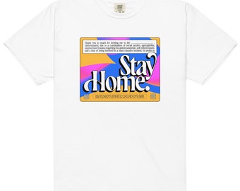 Puede incluir: Camiseta blanca con un estampado gráfico de un cuadrado colorido con el texto "Stay Home". El texto está en negrita, sin serif.