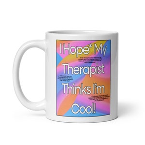 Könnte beinhalten: Weiße Keramik-Kaffeetasse mit einem farbenfrohen Grafikdesign, auf dem "Ich hoffe, mein Therapeut findet mich cool!" steht. Das Grafikdesign zeigt einen Farbverlauf von Pink, Orange, Gelb und Blau.