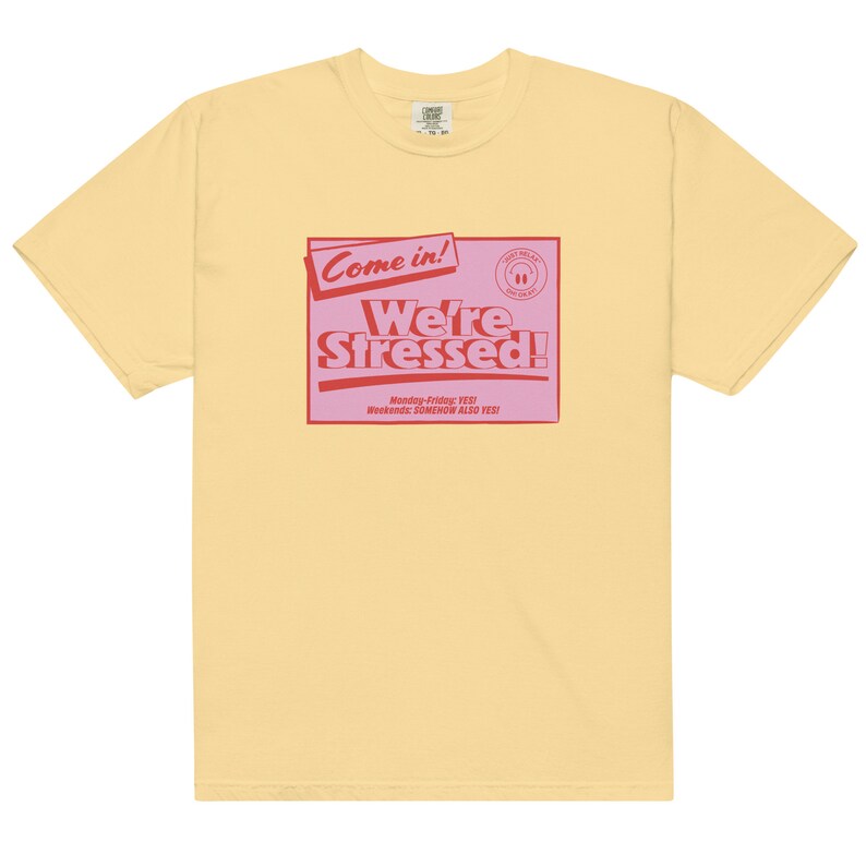 K&ouml;nnte beinhalten: Ein gelbes T-Shirt mit einer pinkfarbenen und roten Grafik, auf der "Come in! We're Stressed!" steht, darunter der Text "Monday-Friday: YES! Weekends: SOMEHOW ALSO YES!"