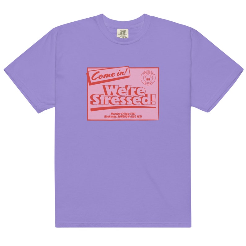 K&ouml;nnte beinhalten: Lilafarbenes T-Shirt mit einer roten Grafik, auf der "Come in! We're Stressed!" steht, darunter der Text "Monday-Friday: YES! Weekends: SOMEHOW ALSO YES!"