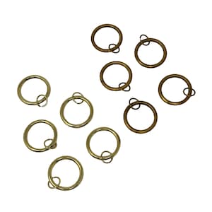 May include: A set of ten gold curtain rings with a small metal loop on each ring. The rings are arranged in two rows on a white background.