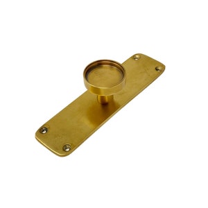 May include: A gold-toned door handle with a round knob and a rectangular base plate. The handle has a brushed finish and is designed for a modern aesthetic.