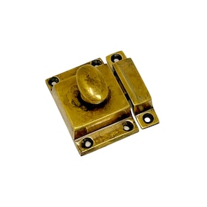May include: A brass cabinet latch with a rounded knob. The latch is in two pieces, one with the knob and the other with a rectangular plate.