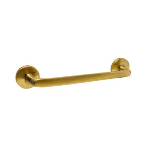 May include: A gold-toned metal door handle with a curved design and round ends.