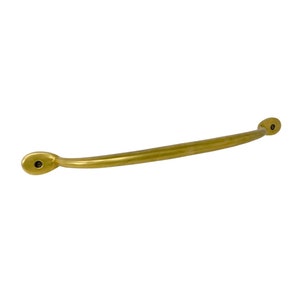 May include: A gold-toned metal cabinet pull with rounded ends. The pull is curved and has a smooth finish.