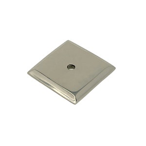May include: A square, silver-toned metal plate with a single hole in the center. The plate has a slightly raised edge.