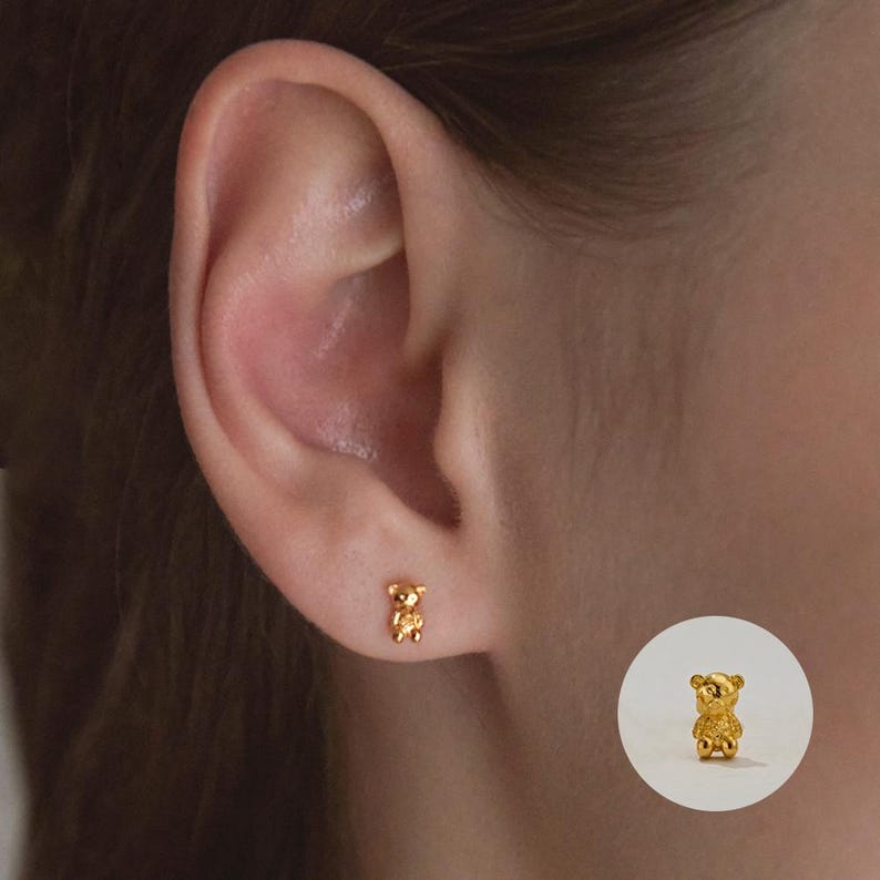 May include: Gold-toned teddy bear stud earrings. The earrings are small and delicate, perfect for everyday wear.